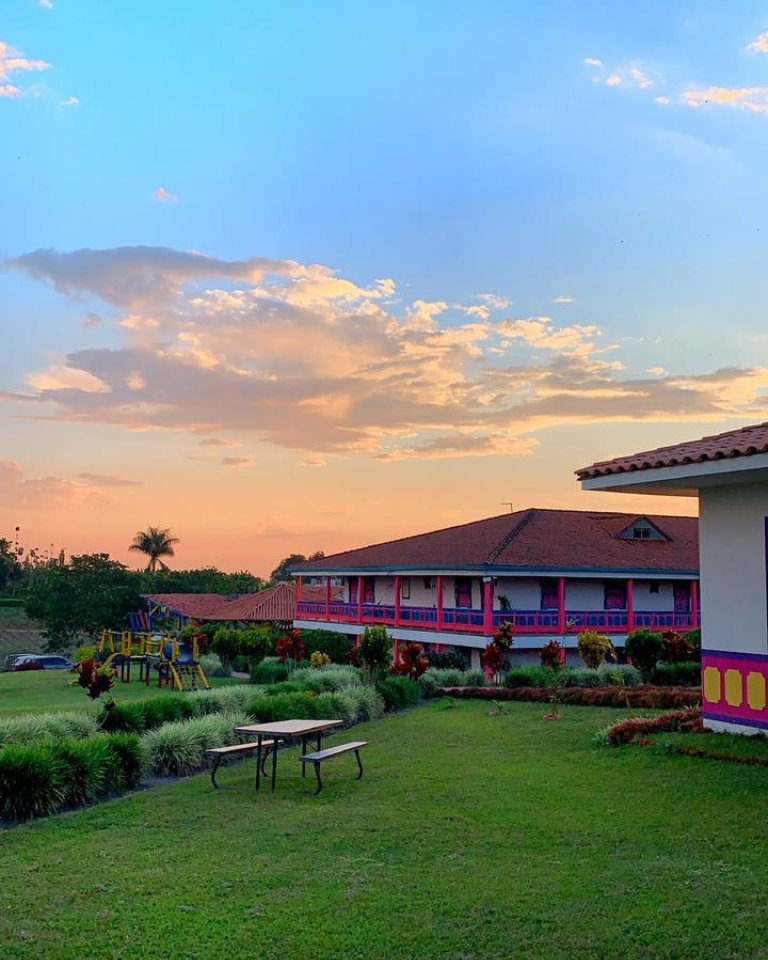 Atardecer sobre el Hotel Arrayanes del Quindío con jardines y un paisaje natural del Eje Cafetero.